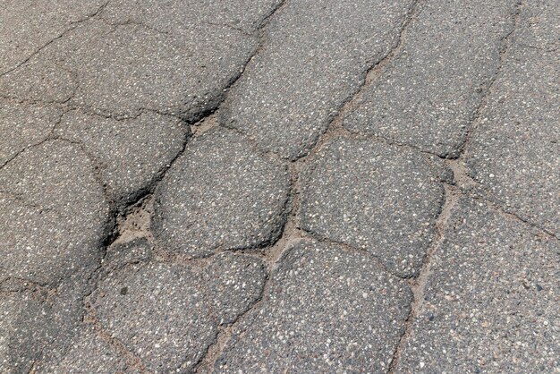 Uma velha estrada pavimentada com muitos buracos e danos