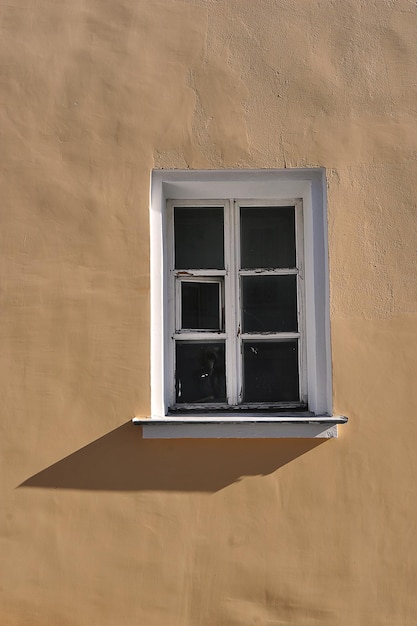 Uma velha janela de madeira em uma parede amarela em uma casa em Kolomna