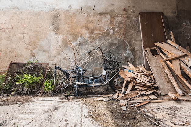 Foto uma velha motocicleta quebrada entre escombros de madeira