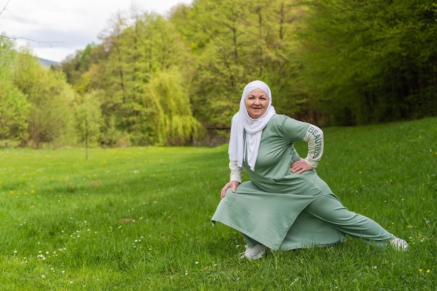 Uma velha muçulmana feliz em exercícios de hijab em um parque de verão Bem-estar de estilo de vida saudável