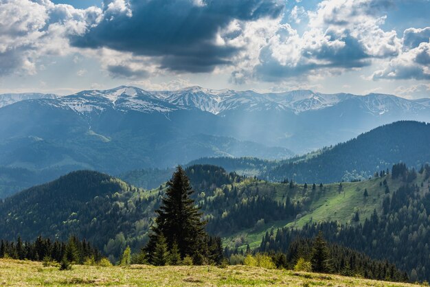 Uma viagem pelas montanhas da primavera com vista para os picos cobertos de neve