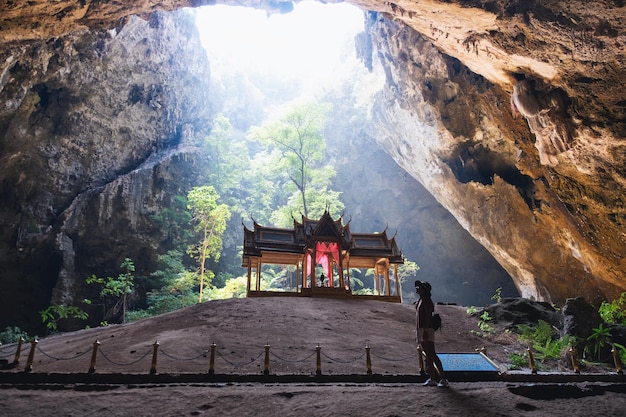 Uma viajante feminina explorando dentro da caverna Phraya Nakorn na província de Prachuap Khiri Khan, Tailândia