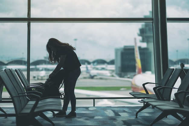 Uma viajante preparando e fazendo as malas no aeroporto