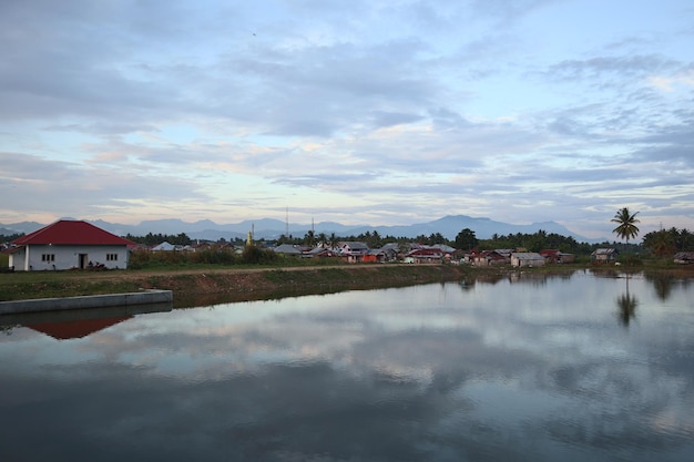 Uma vila perto da água com montanhas ao fundo