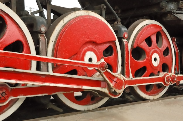 Uma visão de close-up de várias rodas grandes de uma locomotiva muito antiga.