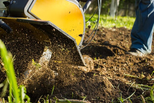 Uma visão de perto no motocultivador durante o processo de arado na temporada de primavera.