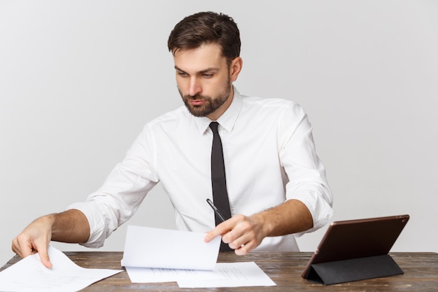Uma visão de um empresário ocupado assinar um documento no escritório contra branco