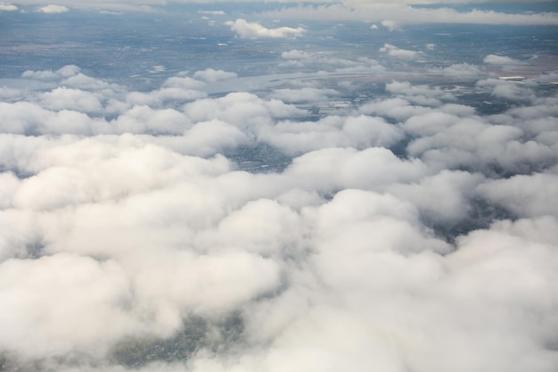 Uma visão do céu de um plano de nuvens com o sol brilhando no topo.