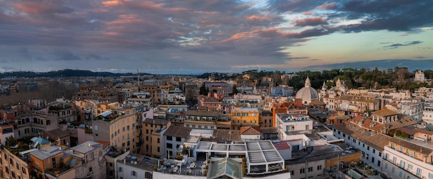 Uma vista aérea de Roma ao anoitecer revela densos edifícios de tons quentes