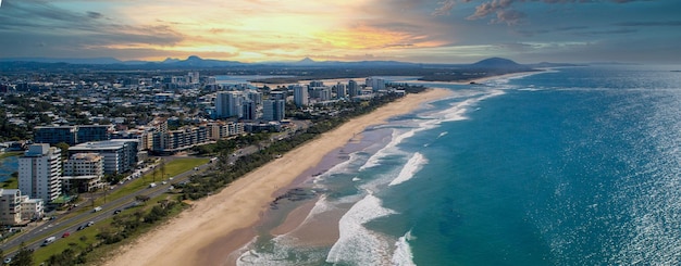 Foto uma vista aérea de tirar o fôlego do oceano e da cidade ao pôr-do-sol em queensland, austrália