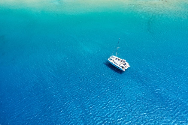 Uma vista aérea do iate no mar azul Água clara transparente no mar Mediterrâneo Férias de verão e viagens em um iate à vela Relaxamento de verão