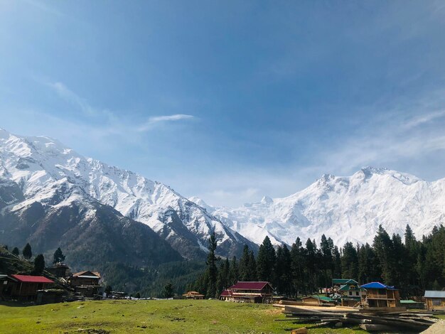 Foto uma vista de uma cordilheira coberta de neve com uma lona azul no topo