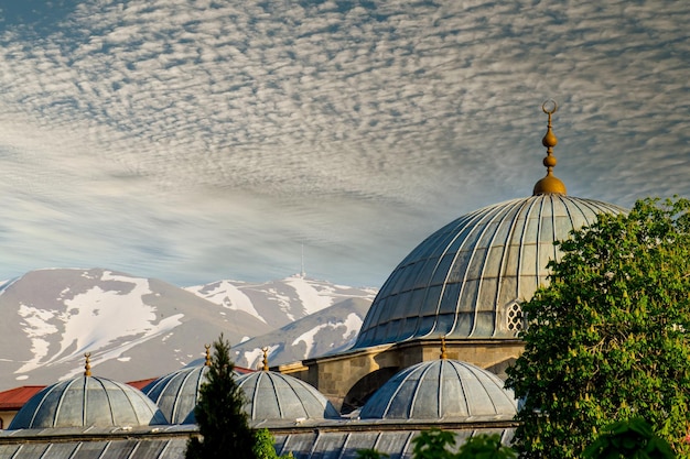 Uma vista de uma mesquita com as montanhas ao fundo Turco Erzurum Lalapasa Camii