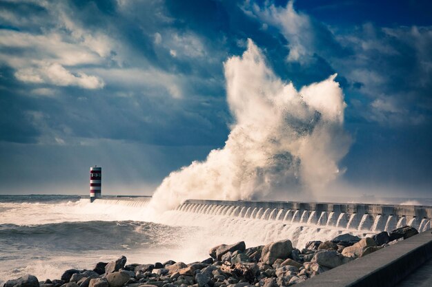 Foto uma vista panorâmica de uma enorme onda a bater no quebra-mares