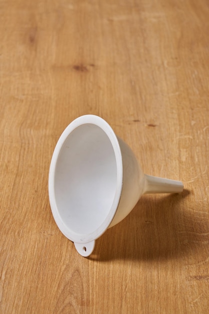 Uma xícara branca está de cabeça para baixo sobre uma mesa de madeira.