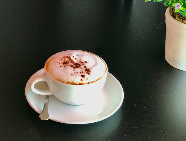 Uma xícara de café cappuccino na mesa preta