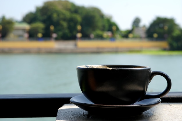 Uma xícara de café cappuccino na vista do rio