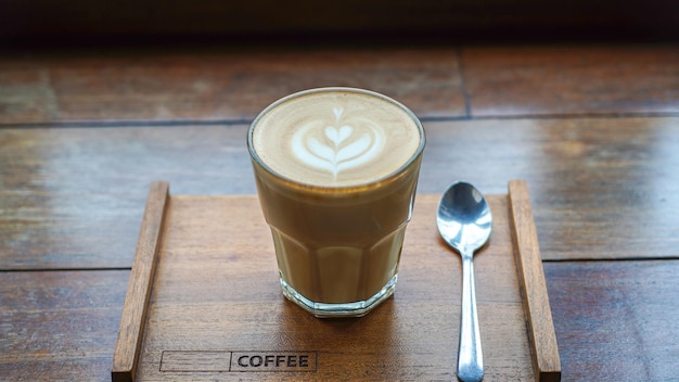 Uma xícara de café cappuccino quente servido em uma tábua de madeira