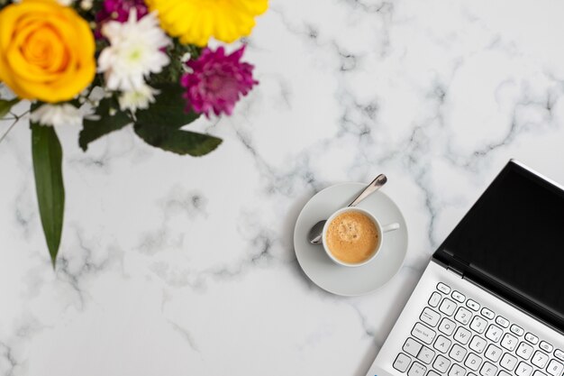 Uma xícara de café com caderno e flores