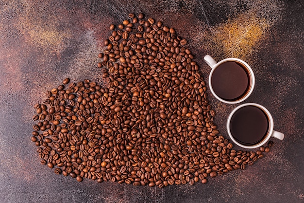 Uma xícara de café com grãos de café em forma de coração, vista de cima