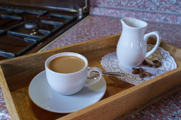 Uma xícara de café com leite e leite antes do fogão a gás na casa de campo