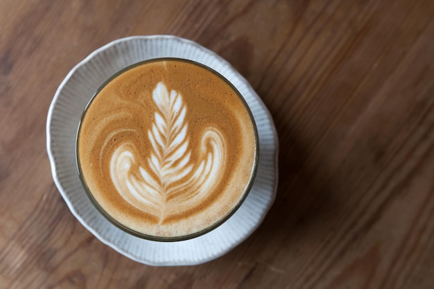 Uma xícara de café com leite na mesa de madeira