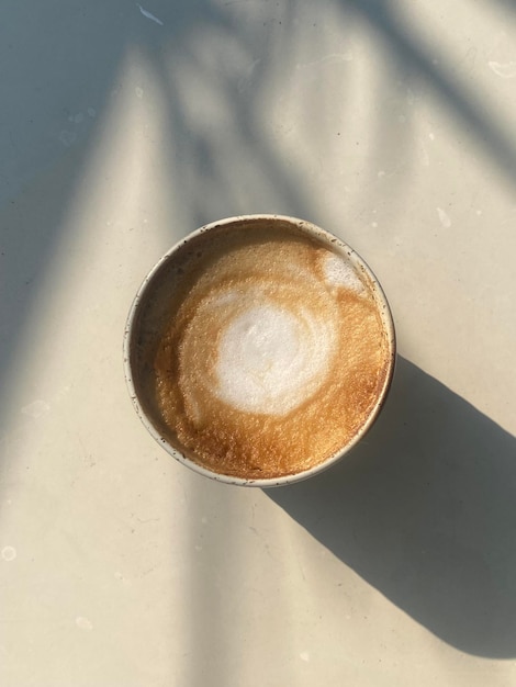 Uma xícara de café com uma tampa branca em cima.