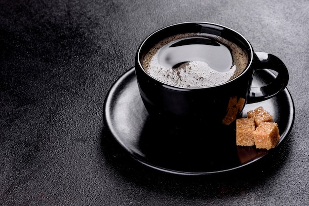 Uma xícara de café da manhã fresco e perfumado para um começo alegre do dia. Xícara de café linda com café em uma mesa escura