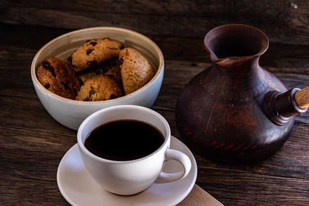 Uma xícara de café e biscoitos de aveia na mesa da cozinha.