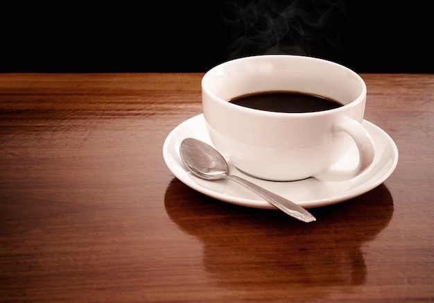 Foto uma xícara de café é colocada sobre uma mesa de madeira