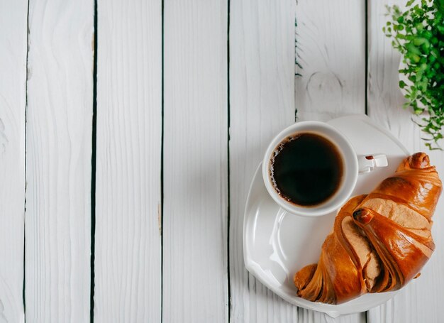 Uma xícara de café e croissants em um prato branco