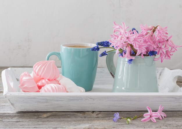 Foto uma xícara de café e um buquê de flores em uma mesa de madeira