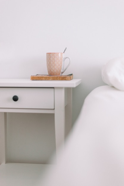 Foto uma xícara de café e um livro na cama