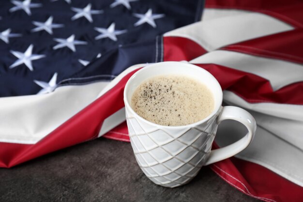 Foto uma xícara de café e uma bandeira americana em fundo cinza