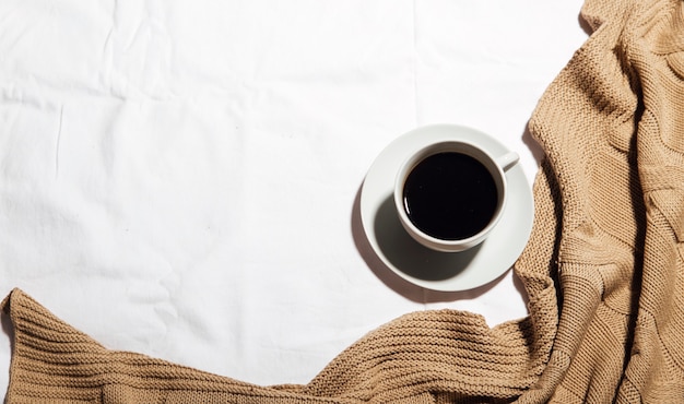 Uma xícara de café em uma cama branca