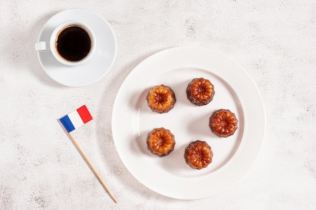 Uma xícara de café expresso canele de sobremesa francesa local e uma bandeira francesa plana lay