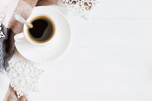 Uma xícara de café, flocos de neve brancos, um cachecol em uma gaiola, brinquedos de Natal