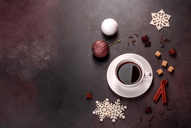 Uma xícara de café forte na mesa de Natal com galhos de abeto e brinquedos. Preparando-se para o feriado