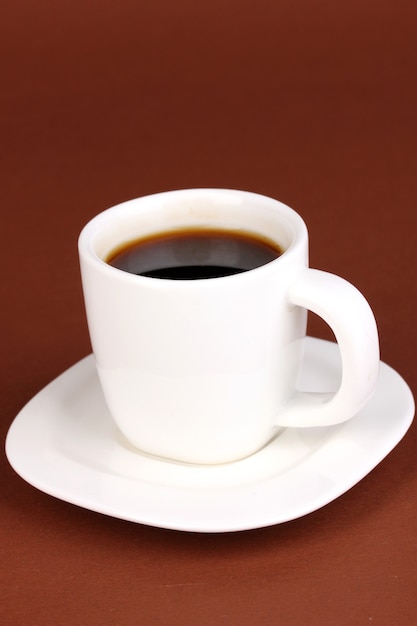 Uma xícara de café forte na superfície marrom