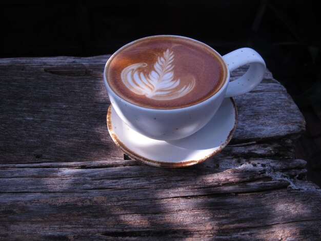 Uma xícara de café latte art em fundo de madeira ..