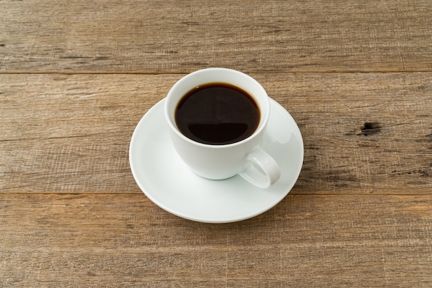 Uma xícara de café na prancha de madeira surrada.