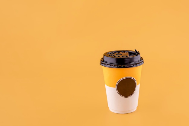 Uma xícara de café para viagem em fundo amarelo