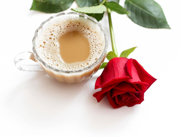 Foto uma xícara de café pela manhã e uma rosa deitada ao lado dela em um fundo claro