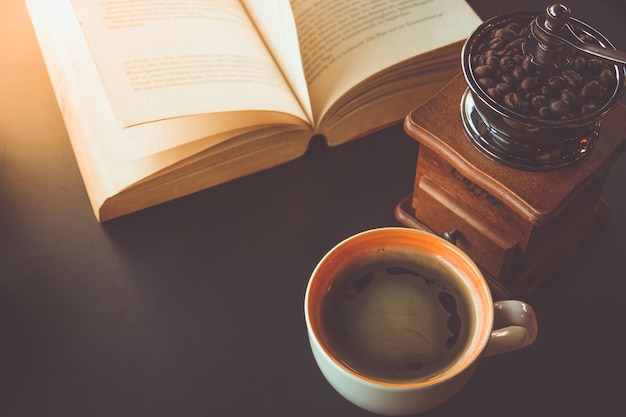 Uma xícara de café preto com livro na mesa