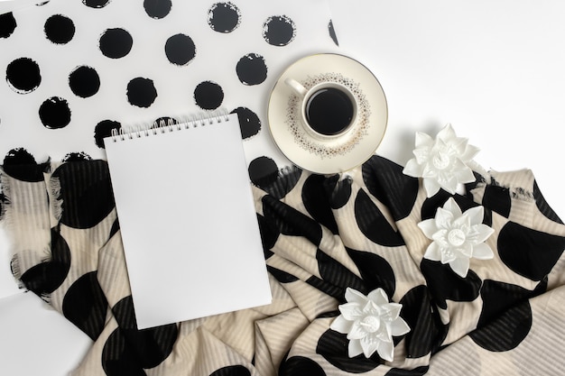 Foto uma xícara de café preto, um bloco de notas, velas em forma de flores de lótus