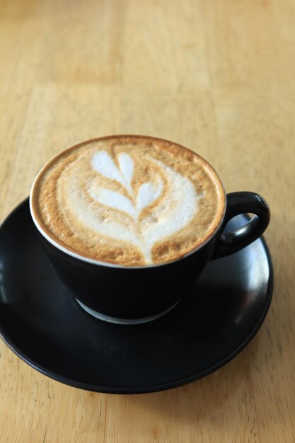 Uma xícara de café tardio com desenho em forma de flor no topo do café