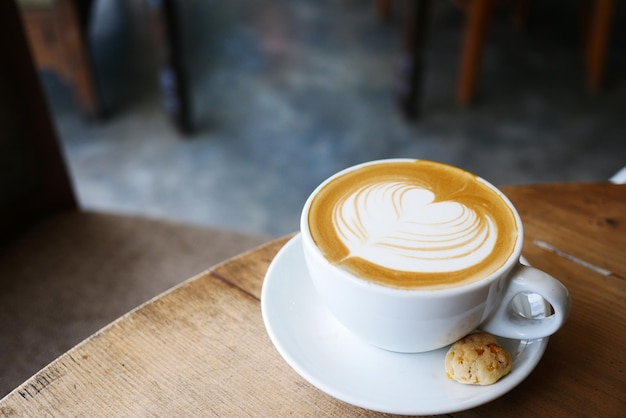 Uma xícara de café tardio com design em forma de coração em cima no café