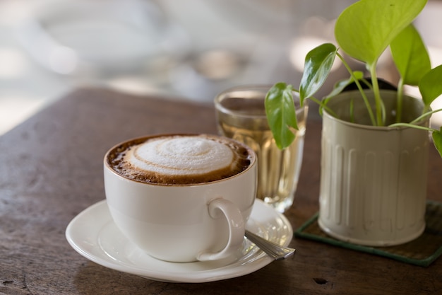 Uma xícara de cappuccino em fundo de madeira