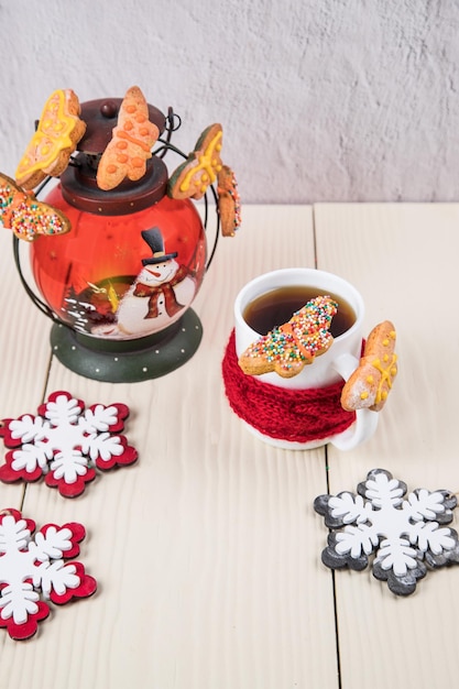 Foto uma xícara de chá com biscoitos caseiros e decorações de natal closeup luz de fundo