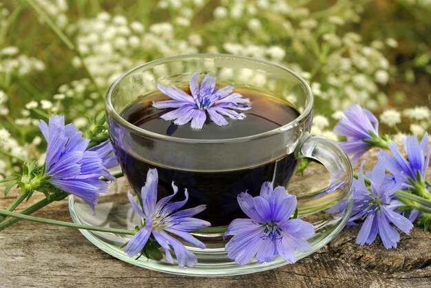 Foto uma xícara de chá com flores roxas em uma mesa de madeira